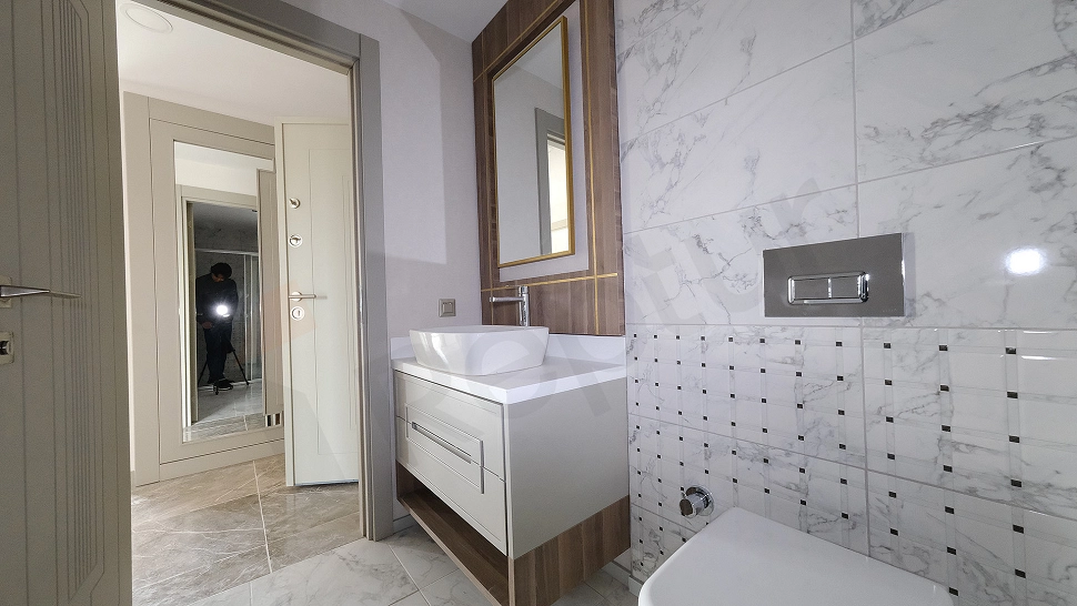 Aydınlık ve modern tasarımlı banyo iç mekanı.