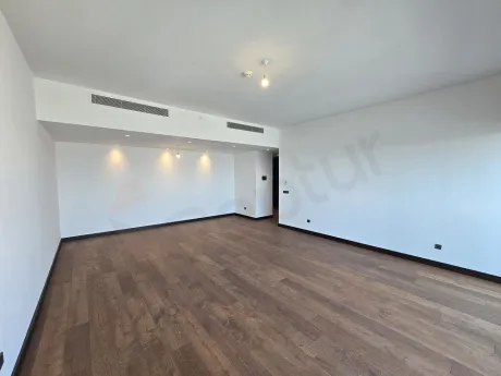 Şişli'de modern mimariye sahip, geniş pencereli ve gün ışığı alan ferah bir oturma odası görseli.