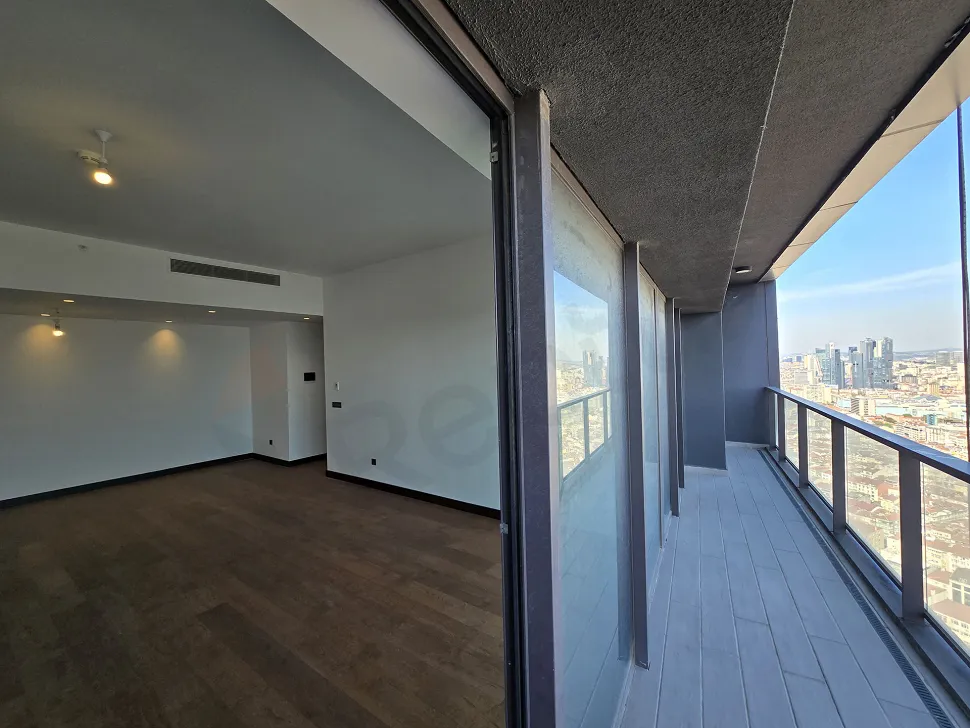 Şehir ve Boğaz manzarasına sahip modern bir rezidans dairesinin balkon görüntüsü.