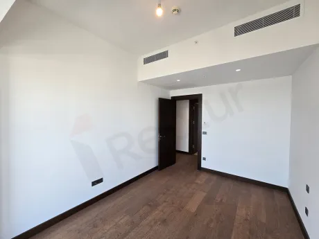 Şişli'deki lüks rezidans projesinde yer alan, geniş pencereli ve modern mimariye sahip aydınlık yatak odası alanı.