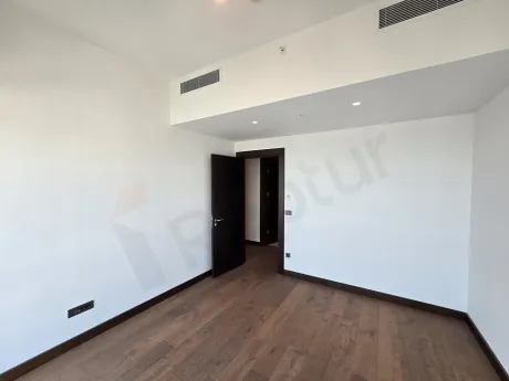 Geniş pencereli, aydınlık ve modern bir yatak odası tasarımı.
