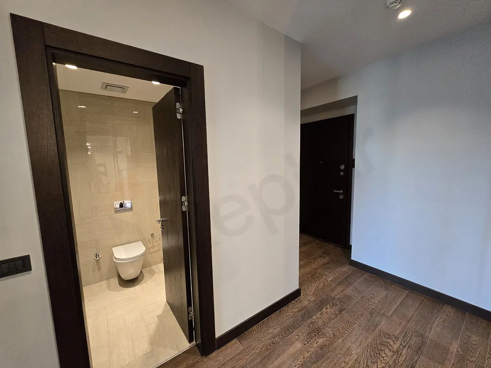 Modern armatürlere ve şık seramik döşemelere sahip lüks bir rezidansın banyo alanı.