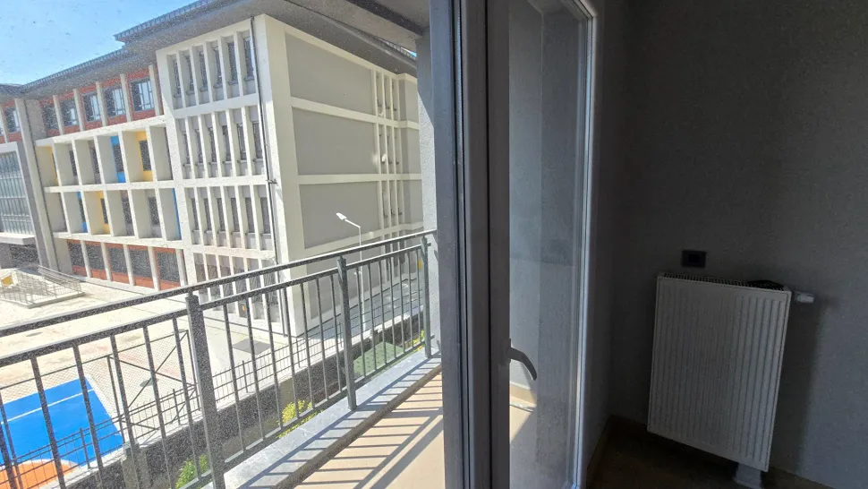 Modern bir binada yer alan geniş balkon alanı ve şehir manzarası.