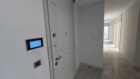 Modern bir binada yer alan lüks bir dairenin geniş ve aydınlık giriş bölümü.