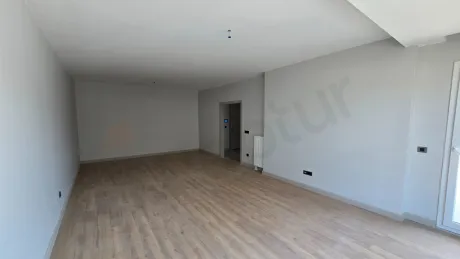 Geniş pencereli, modern iç tasarıma sahip ferah ve aydınlık bir oturma odası görseli.