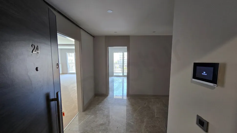 Modern bir dairenin giriş holü ve kapı alanı görünümü.