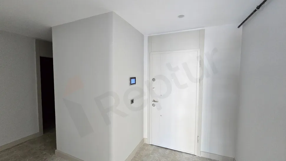 Modern bir dairenin giriş kapısı ve antre bölümü.
