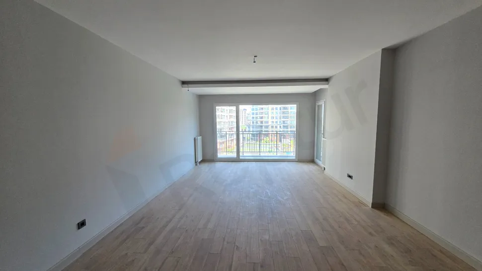 Beylikdüzü'nde modern bir binada yer alan, geniş pencereli ve ferah tasarımlı aydınlık oturma odası.
