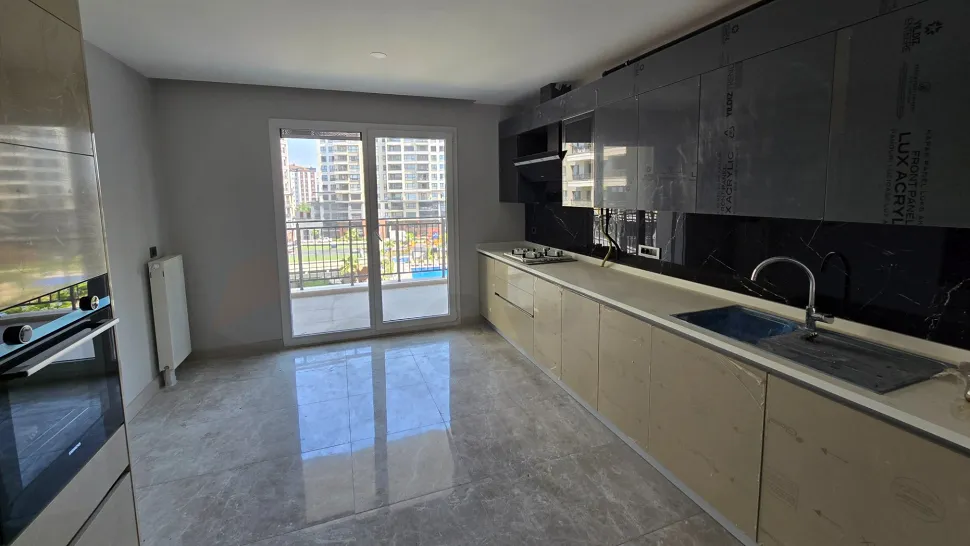 Modern ve geniş tasarıma sahip, aydınlık bir lüks daire mutfağı.