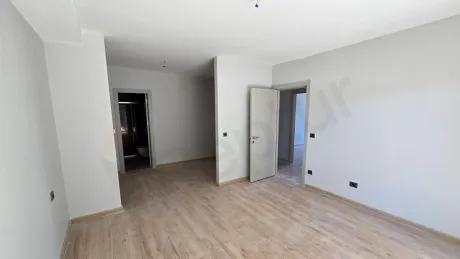 Modern ve ferah tasarımlı, geniş pencereli bir yatak odası görünümü.