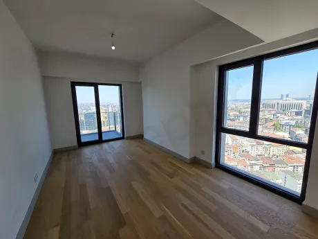 Şişli'de modern mimariye sahip, geniş pencereli ve şehir manzaralı aydınlık oturma odası alanı.