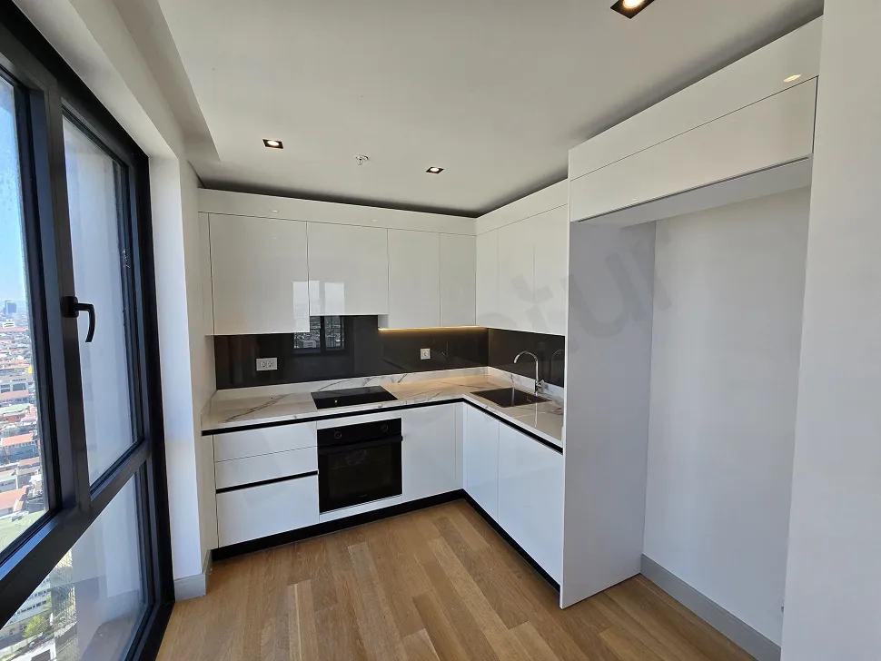 Şişli'deki lüks bir dairede modern tasarımlı, ankastre dolaplı ve geniş tezgahlı mutfak alanı.