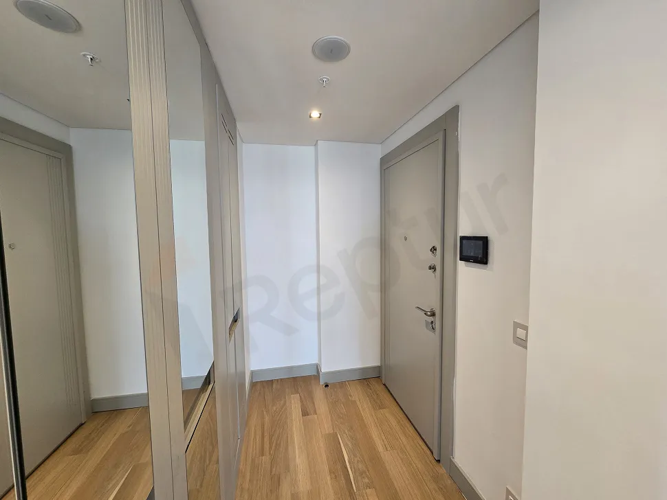 Şişli'de yer alan 1+1 lüks rezidans dairesinin modern tasarımlı giriş kapısı ve antre alanı.