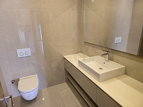 Modern tasarımlı, geniş ve lüks bir banyo iç mekanı. Açık renk tonları, doğal taş detayları ve şık armatürler dikkat çekiyor.