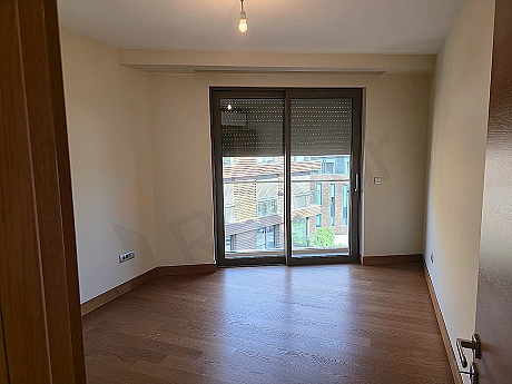 Modern tasarımlı, aydınlık ve geniş yatak odası görseli. Büyük yatak, şık komodinler, abajurlar ve geniş pencereler.