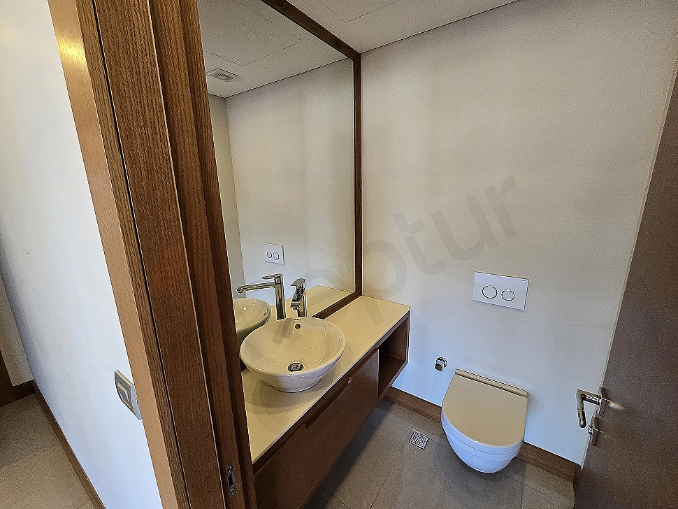 Modern tasarımlı, geniş ve aydınlık dubleks daire banyo iç mekanı. Şık lavabo, geniş ayna ve duşakabin detayları.