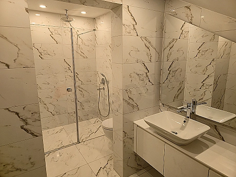 Lüks banyo iç mekanı, modern tasarım, geniş lavabo, aynalı dolap ve aydınlık atmosfer.