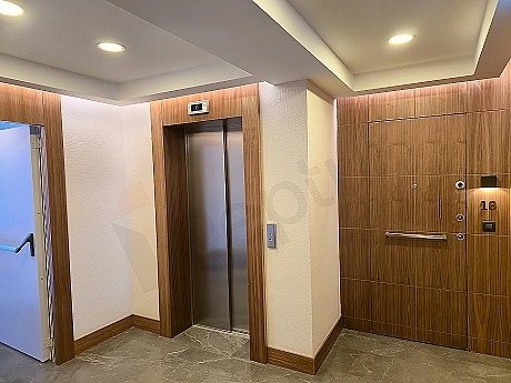 Modern asansör kabini iç görünümü, paslanmaz çelik detaylar ve aydınlatma