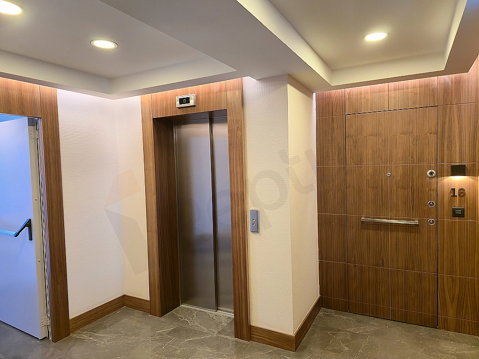 Modern asansör kabini iç görünümü, paslanmaz çelik detaylar ve aydınlatma
