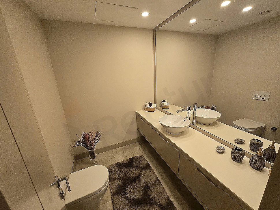 Modern tasarımlı, geniş ve lüks bir banyo iç mekanı. Aydınlık, ferah, ahşap detaylar ve şık armatürler.