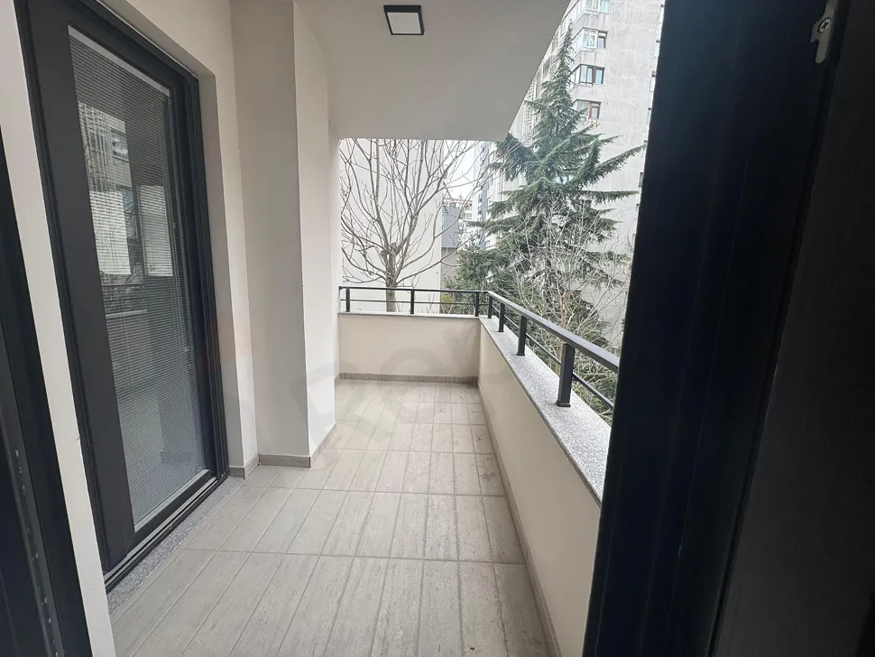 Şehir manzaralı geniş ve modern bir apartman balkonu.