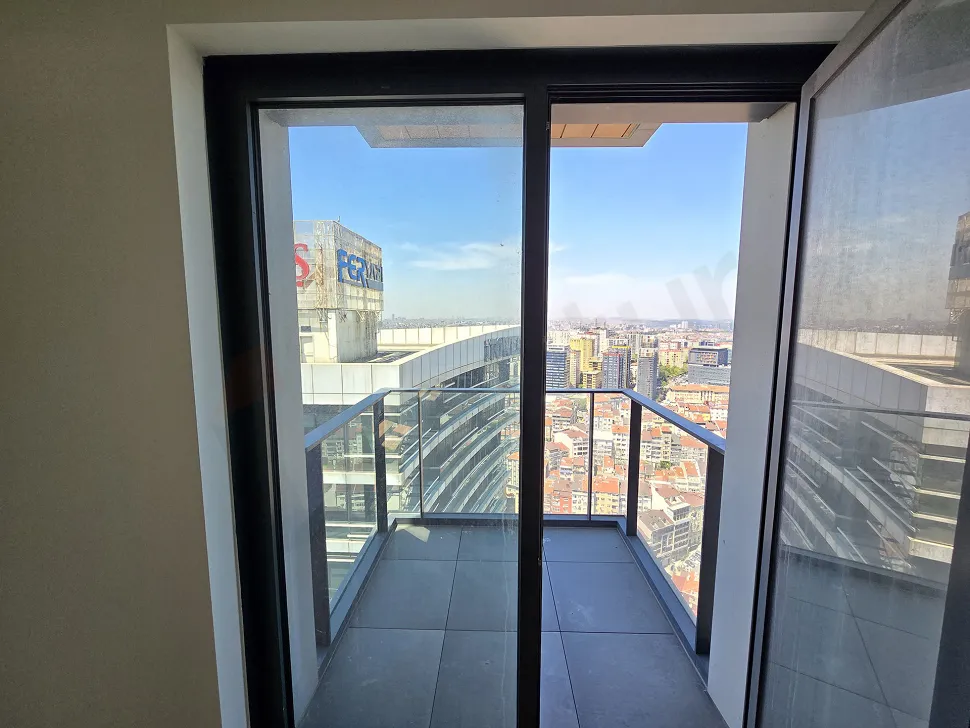 Modern bir apartman dairesinin şehir manzarasına açılan geniş ve ferah balkonu.
