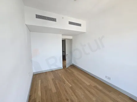 Modern tasarımlı, geniş pencereli ve gün ışığı alan ferah bir yatak odası görünümü.