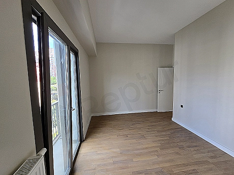Modern yatak odası iç mekanı. Çift kişilik yatak, komodin, abajur ve şehir manzaralı pencere.