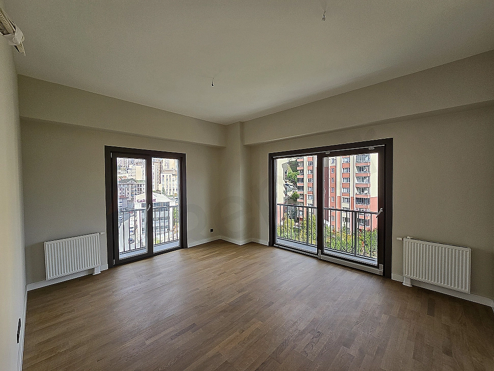Modern tasarımlı, eşyasız 2+1 daire oturma odası.