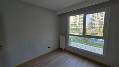 Modern ve geniş pencereli, aydınlık bir yatak odası görünümü.