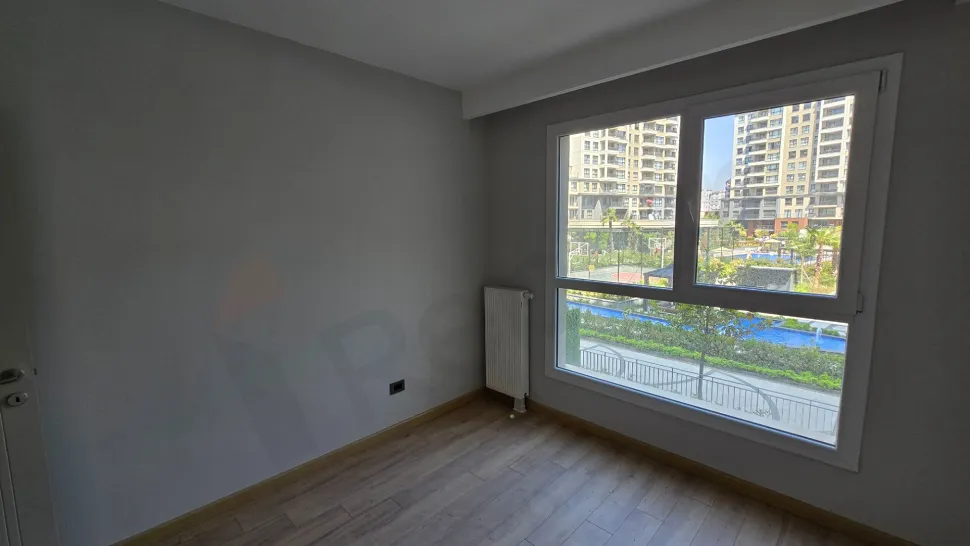 Modern ve geniş pencereli, aydınlık bir yatak odası görünümü.