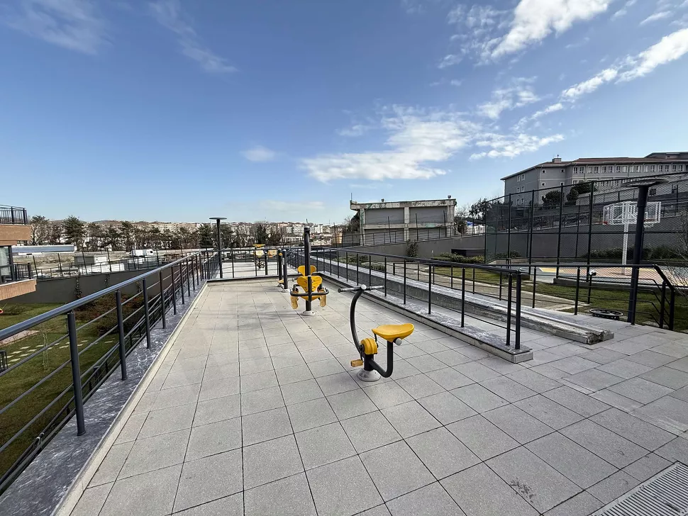 Site bahçesinde yer alan, çeşitli oyun düzeneklerine ve güvenli zemine sahip modern çocuk parkı alanı.