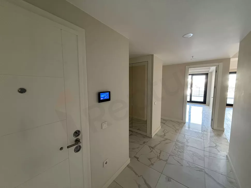Modern bir binada yer alan dairenin giriş kapısı ve antre bölümü.