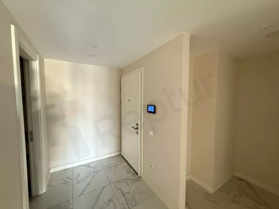 Modern bir dairenin giriş kapısı ve geniş antre bölümünün görünümü.