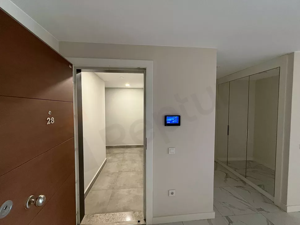 Modern bir dairenin giriş kapısı ve antre bölümü görünümü.