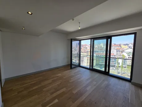 Şişli'deki lüks bir projenin modern ve geniş pencereli boş oturma odası alanı.