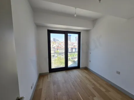 İstanbul Şişli'de satılık 2+1 dairenin geniş pencereli, gün ışığı alan modern yatak odası bölümü.