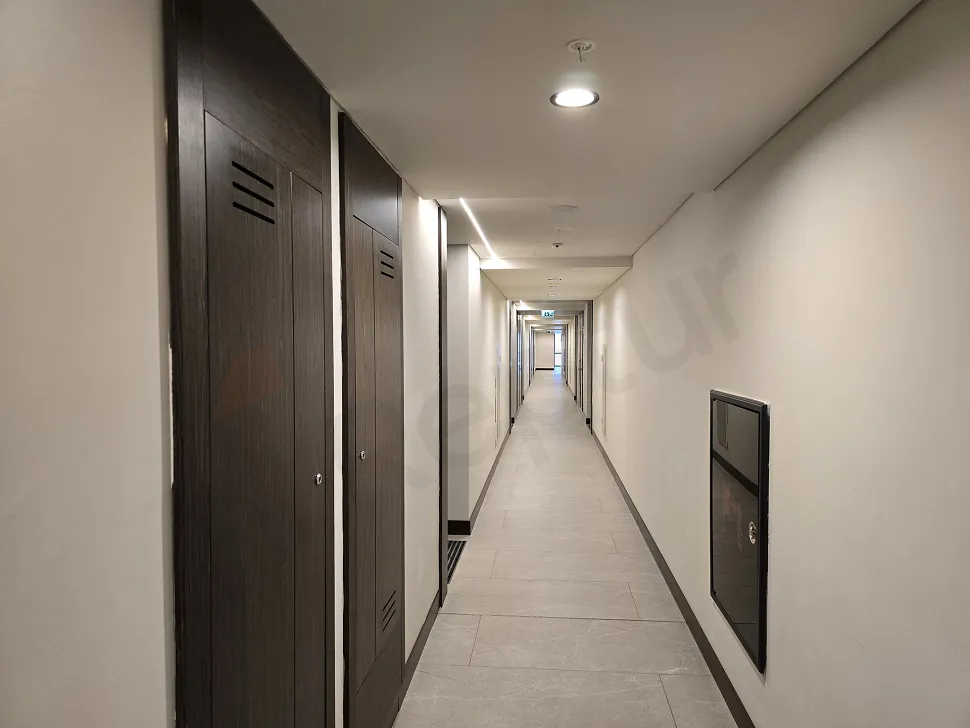 Modern ve şık bir binada yer alan, aydınlık ve geniş bir daire koridoru.