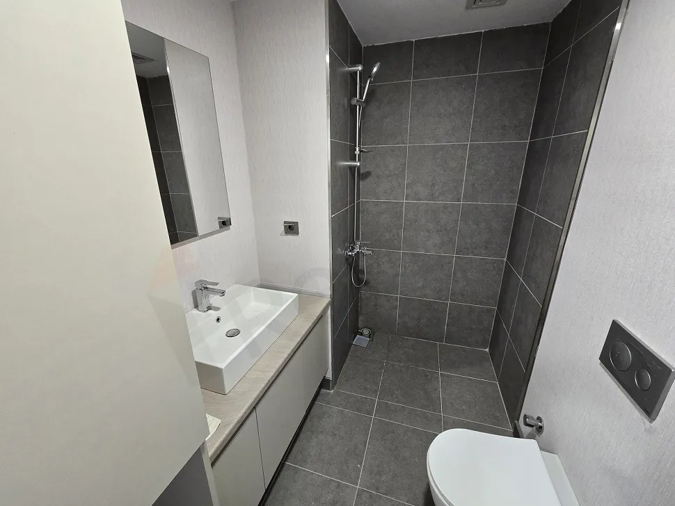 Modern tasarımlı, seramik kaplı şık banyo alanı.