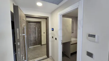 Modern bir dairenin giriş kapısı ve antre alanı görünümü.