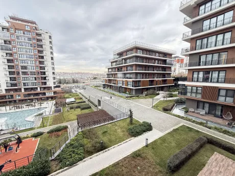 Yeşil alanları ve peyzaj düzenlemesiyle modern bir apartman bahçesi.