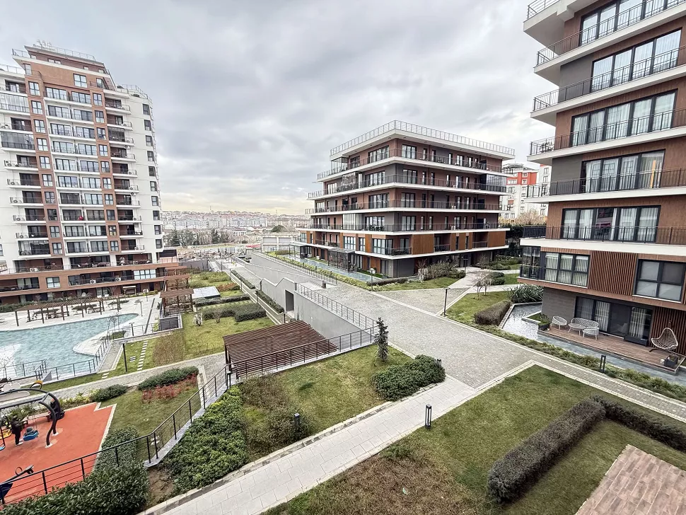 Yeşil alanları ve peyzaj düzenlemesiyle modern bir apartman bahçesi.