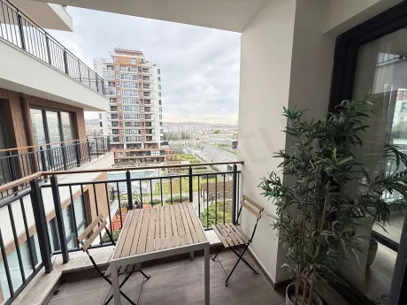 Modern mobilyalarla dekore edilmiş, geniş ve aydınlık bir balkon görünümü.