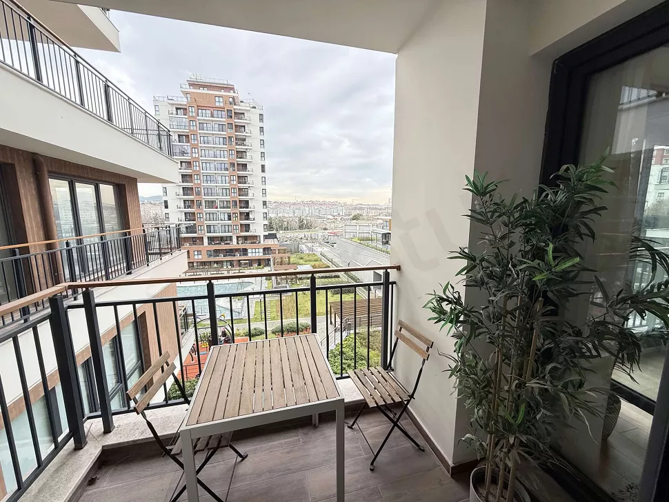 Modern mobilyalarla dekore edilmiş, geniş ve aydınlık bir balkon görünümü.