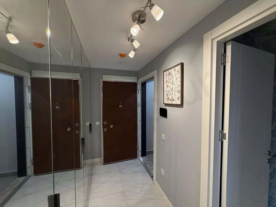 Modern tasarımlı bir dairenin giriş bölümü ve kapısı.