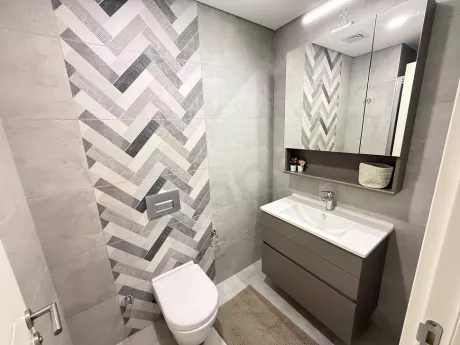 Modern armatürler ve şık kaplamalarla tasarlanmış, ferah ve aydınlık bir banyo iç mekan görünümü.