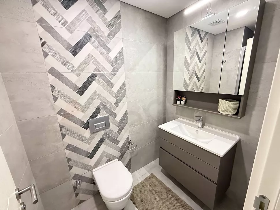 Modern armatürler ve şık kaplamalarla tasarlanmış, ferah ve aydınlık bir banyo iç mekan görünümü.