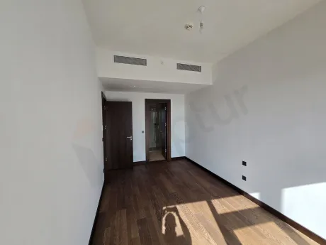 Şişli'de lüks bir rezidans dairesinin modern tasarımlı ve şehir manzaralı aydınlık yatak odası.