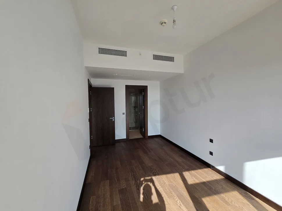 Şişli'de lüks bir rezidans dairesinin modern tasarımlı ve şehir manzaralı aydınlık yatak odası.