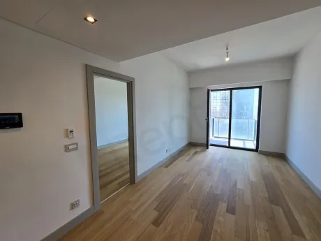 Şişli'de modern bir rezidans dairesinin geniş pencereli, şehir manzaralı ve gün ışığı alan ferah oturma odası.